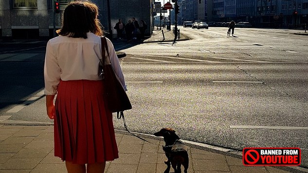 a woman with a dog on a mostly empty street
